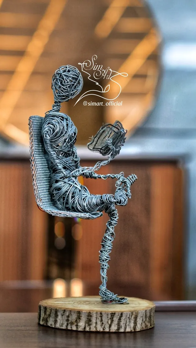 Reader in a mesh chair — wire sculpture by Pouya